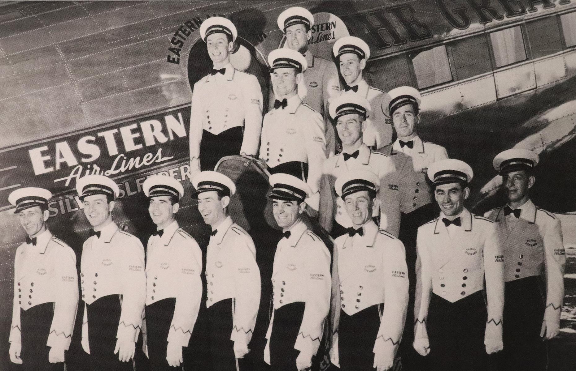 Slide 10 of 51: In the 1920s and into early 1930s, the role of flight attendant was one mostly reserved for men, who were usually referred to as "cabin boys". This was soon flipped on its head, though. The first female flight attendant, a nurse named Ellen Church, was employed in 1930 and by the middle of the decade most of these jobs went to women. The women were often also trained nurses and there were strict rules as to their age, height and weight. Before this change, this photo shows an all-male team of air stewards posing before an Eastern Air Lines plane in the early 1930s.