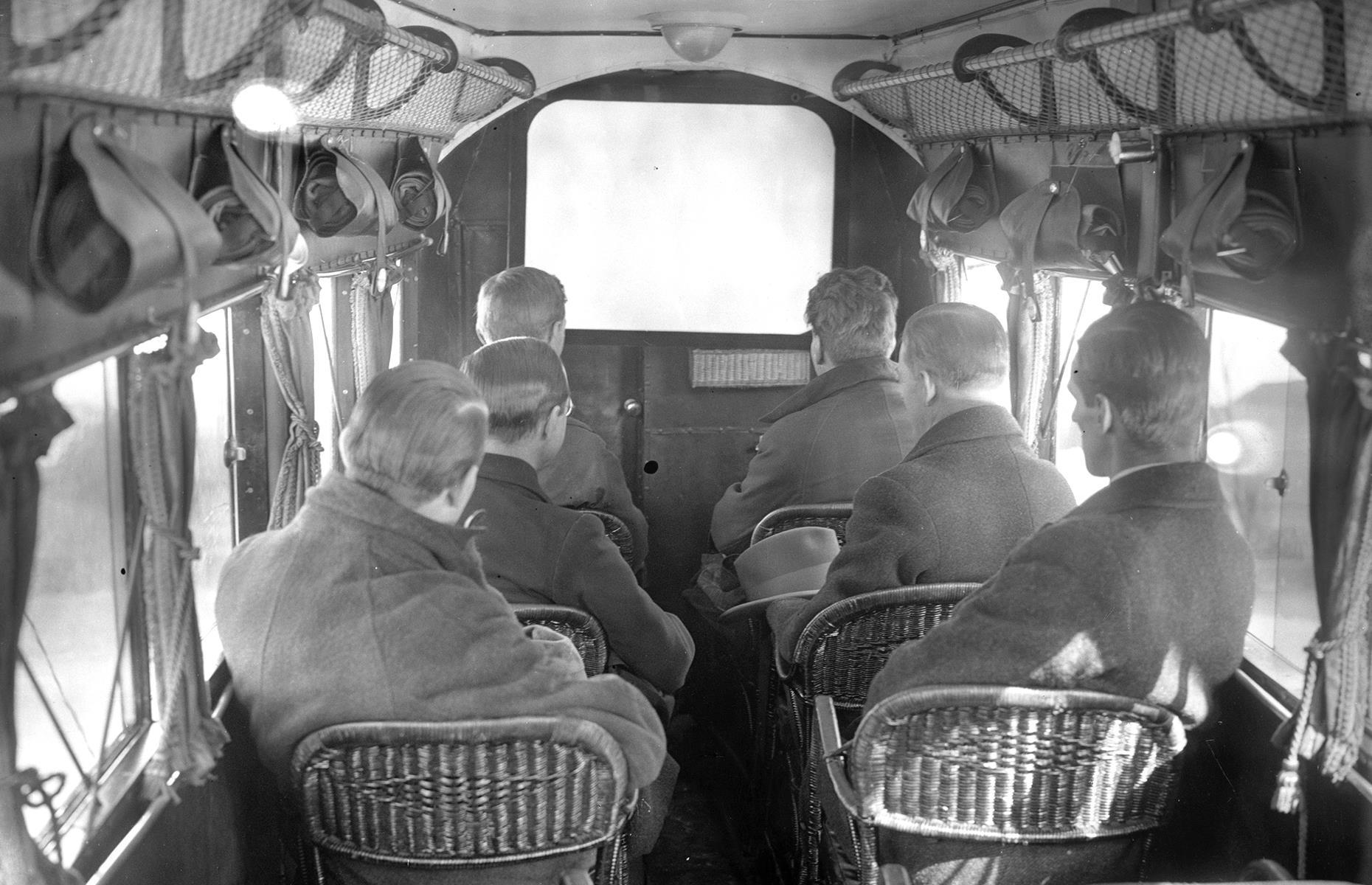 Slide 6 of 51: In-flight entertainment systems looked rather different too. Today airplane entertainment is a solitary affair, but in the early days of flight passengers would gather around a single screen if they wanted to catch a movie. One of the earliest films to be shown up high was Sir Arthur Conan Doyle's The Lost World in 1925 with Imperial Airways. Here, passengers on a German airliner also enjoy a movie in the year 1925. 