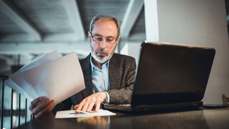 a man sitting at a table using a laptop