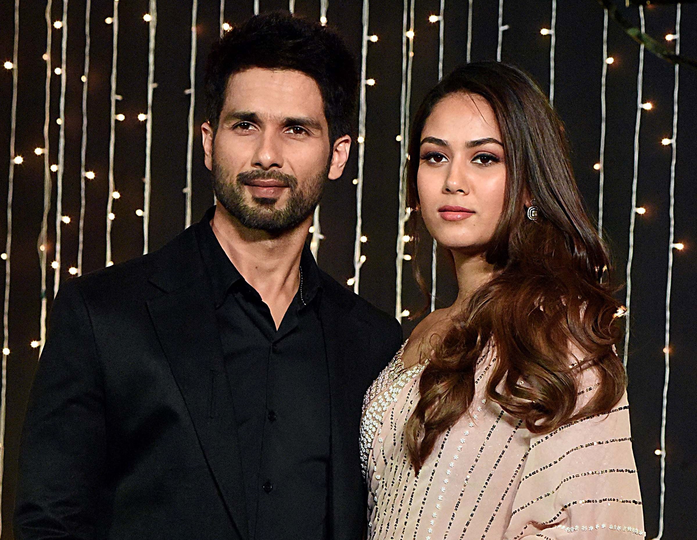 Slide 4 of 30: Indian Bollywood actor Shahid Kapoor (L) with his wife Mira Rajput pose for a picture during the wedding reception party of actress Priyanka Chopra and US musician Nick Jonas in Mumbai on December 20, 2018. - (Photo by Sujit Jaiswal / AFP) (Photo credit should read SUJIT JAISWAL/AFP/Getty Images)