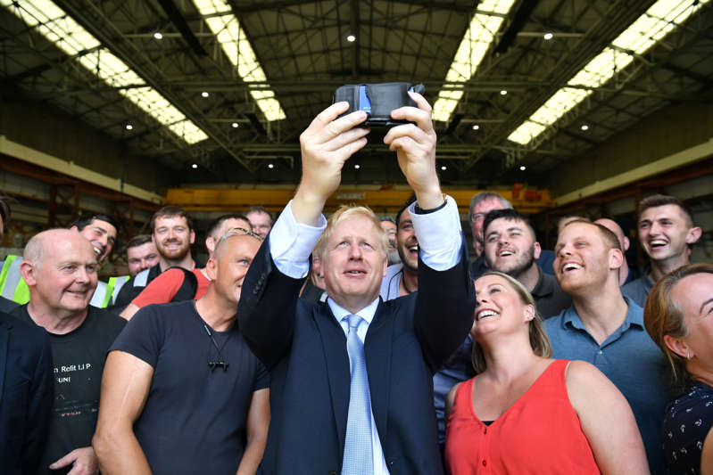 保守党领袖候选人鲍里斯·约翰逊于2019年6月27日访问英国怀特岛时，在Venture Quay的怀特船厂公司与工人一起拍照。多米尼克利普辛斯基/泳池通过路透社