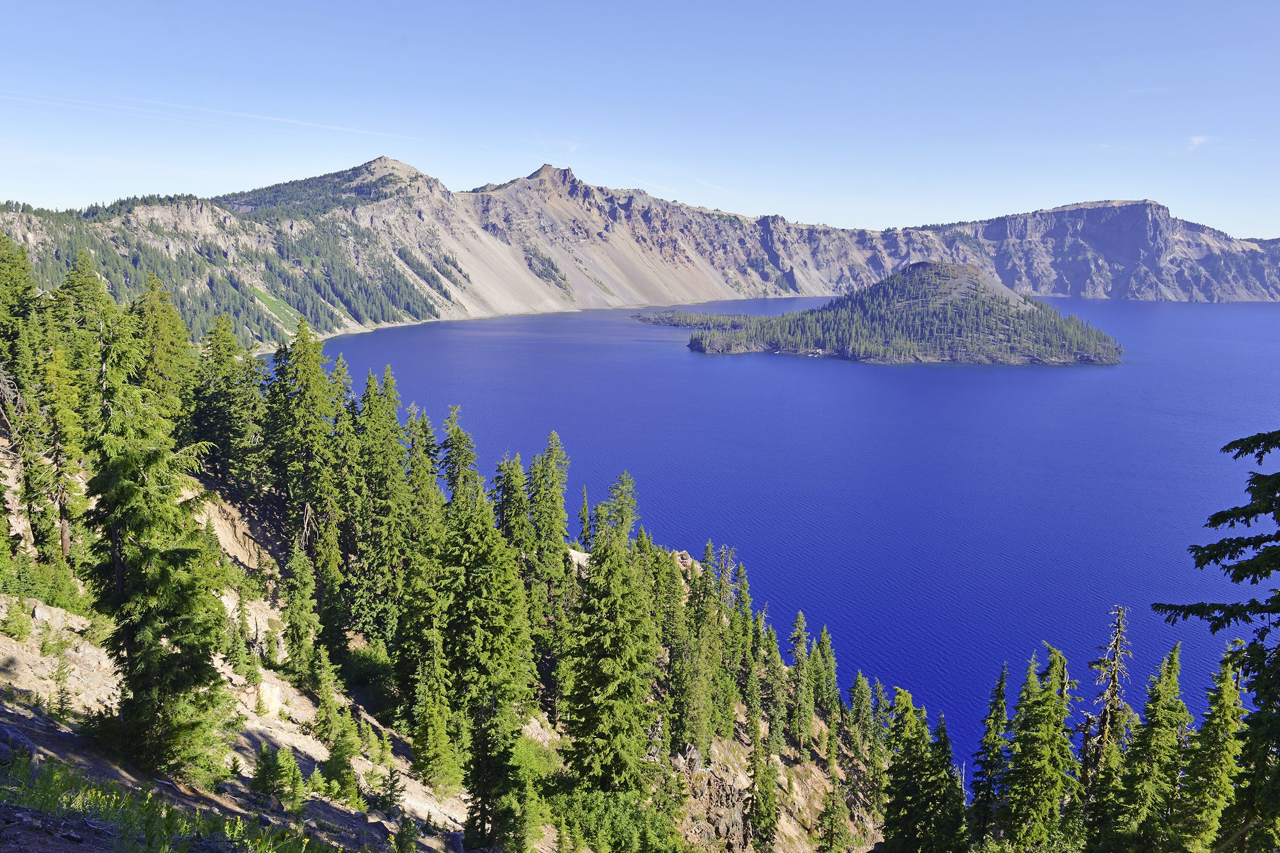 <p>Crater Lake National Park is home to the deepest lake in the United States. The lake fills the caldera of a dormant volcano, and visitors can drive, hike, take a trolley, or ride a bike along the rim to peer into the lake from different vantage points. Steep cliffs limit access to the water, but visitors can hike several trails and take a boat tour around the lake's perimeter or to Wizard Island, a volcanic cinder cone that rises about 760 feet out of the water.</p>