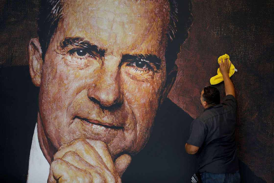 In this Wednesday, Oct. 5, 2016 photo, Tayron Santos cleans the newly-installed wall mural of former President Richard Nixon in the lobby area of the Richard Nixon Presidential Library and Museum in Yorba Linda, Calif. The museum will reopen Friday, Oct. 14, following a $15 million makeover aimed at bringing the countryâ€™s 37th president closer to younger generations less familiar with his groundbreaking trip to China or the Watergate scandal. (AP Photo/Jae C. Hong)