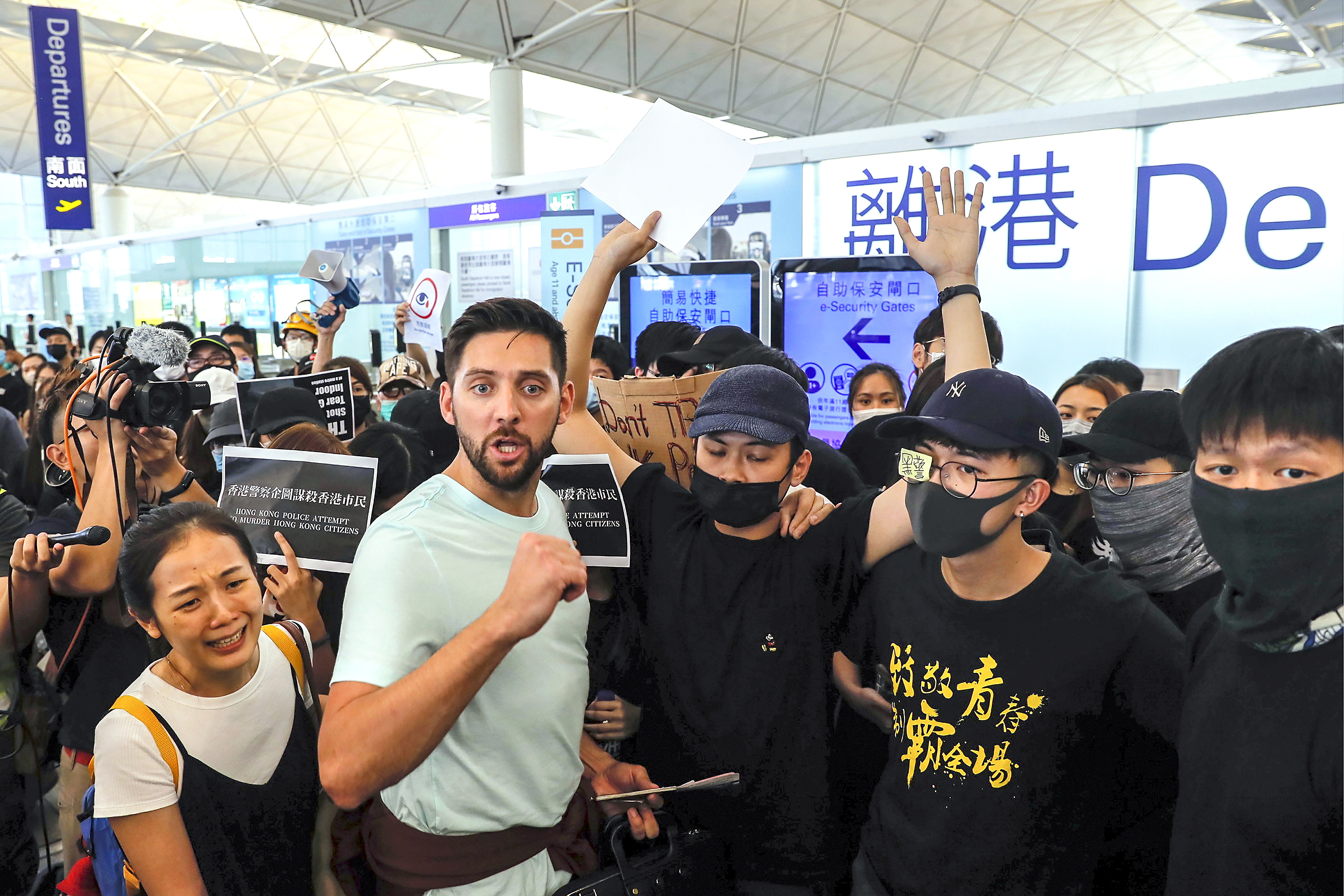 Slide 1 of 50: Travelers react as they try to break through the protesters at the departure gate of the Airport in Hong Kong, on Aug. 13. Protesters severely crippled operations at Hong Kong's international airport for a second day Tuesday, forcing authorities to cancel all remaining flights out of the city after demonstrators took over the terminals as part of their push for democratic reforms.