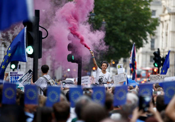 Slide 2 of 54: An anti-Brexit protestor releases colored smoke, outside the Houses of Parliament in London, Britain August 28, 2019. REUTERS/Henry Nicholls TPX IMAGES OF THE DAY