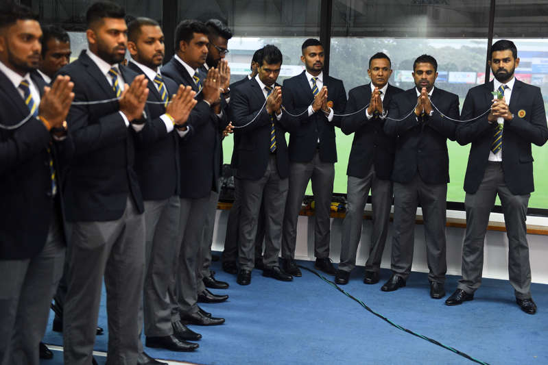 Sri Lanka's cricket captain Lahiru Thirimanne (R) and teammates look on as Buddhist monks chant prayers for their success during a ceremony in Colombo on Septemer 24, 2019, prior to the team's departure for a cricket tour in Pakistan.