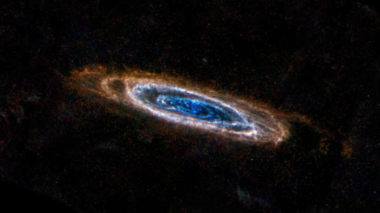 Slide 34 of 86: The ring-like swirls of dust filling the Andromeda galaxy stand out colorfully in this new image from the Herschel Space Observatory, a European Space Agency mission with important NASA participation. The glow seen here comes from the longer-wavelength, or far, end of the infrared spectrum, giving astronomers the chance to identify the very coldest dust in our galactic neighbor