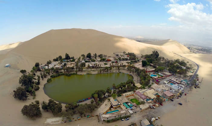 Слайд 4 из 16: Aerial view of the Huacachina Oasis in Ica, Peru, some 300 km south of Lima on December 11, 2014, one of Ica's main attractions, located just 5 km from the departamental capital. AFP PHOTO / MARTIN BERNETTI (Photo credit should read MARTIN BERNETTI/AFP/Getty Images)