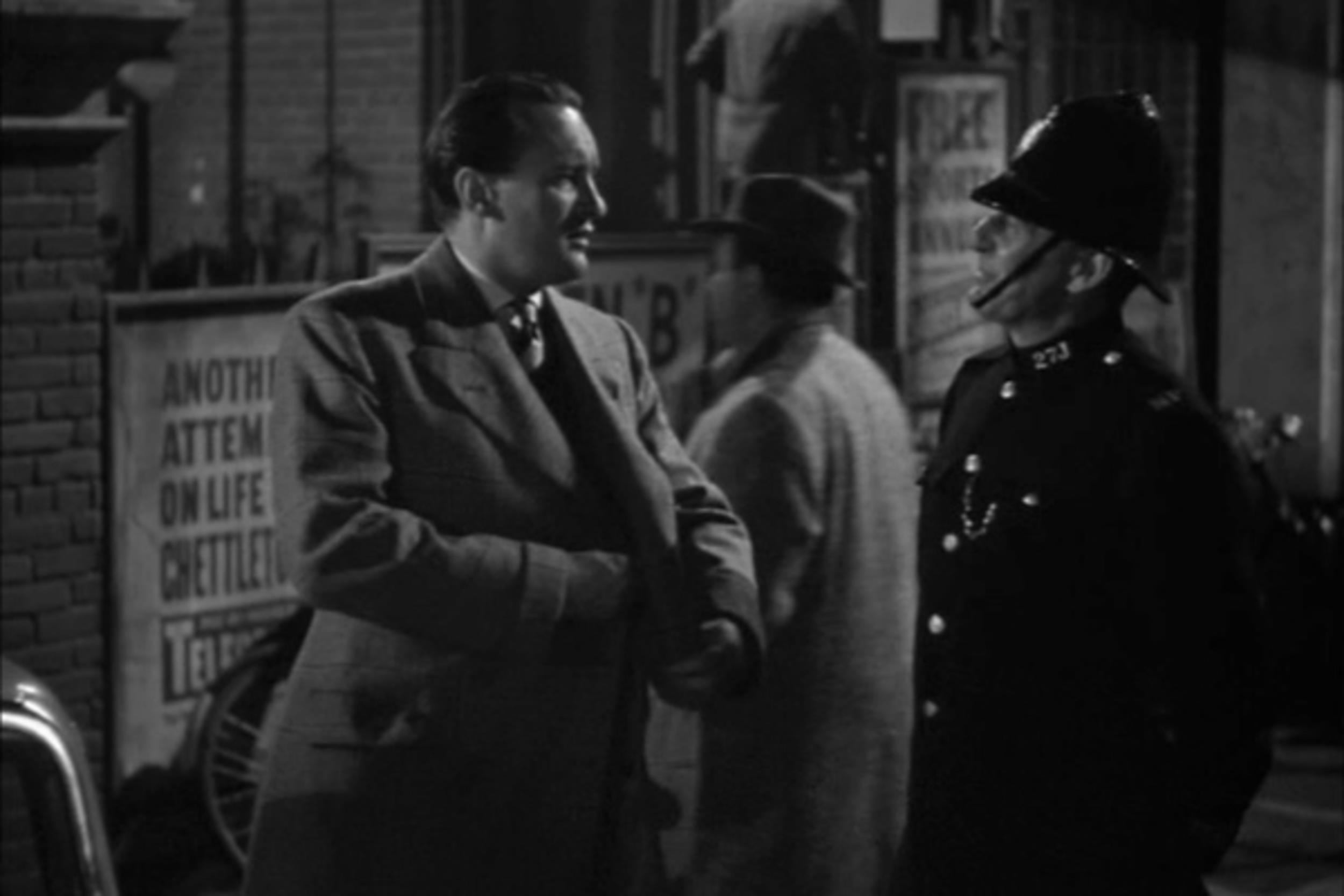 <p>Hitchcock came to America and immediately made a splash. While he didn’t win Best Director, “Rebecca” won Best Picture, the only Hitchcock film to do so. As Jack Favell talks to a police officer, Hitchcock makes a quick pass in the background. Hey, this time he’s not out front!</p>