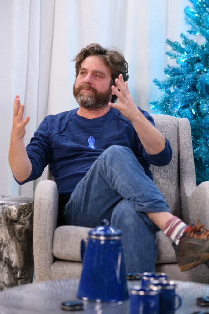 Zach Galifianakis sitting in front of a window