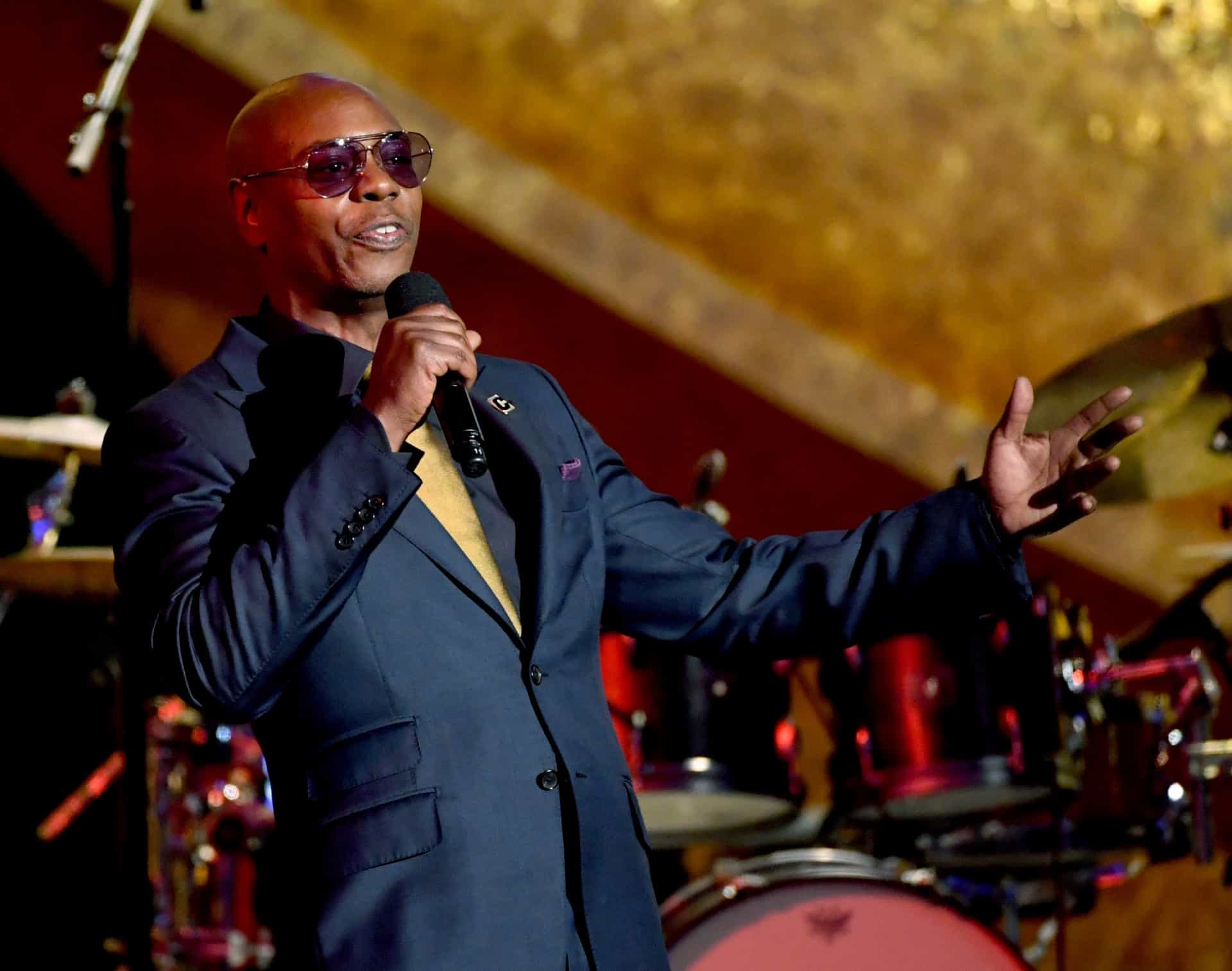 Dave Chappelle holding a wine glass