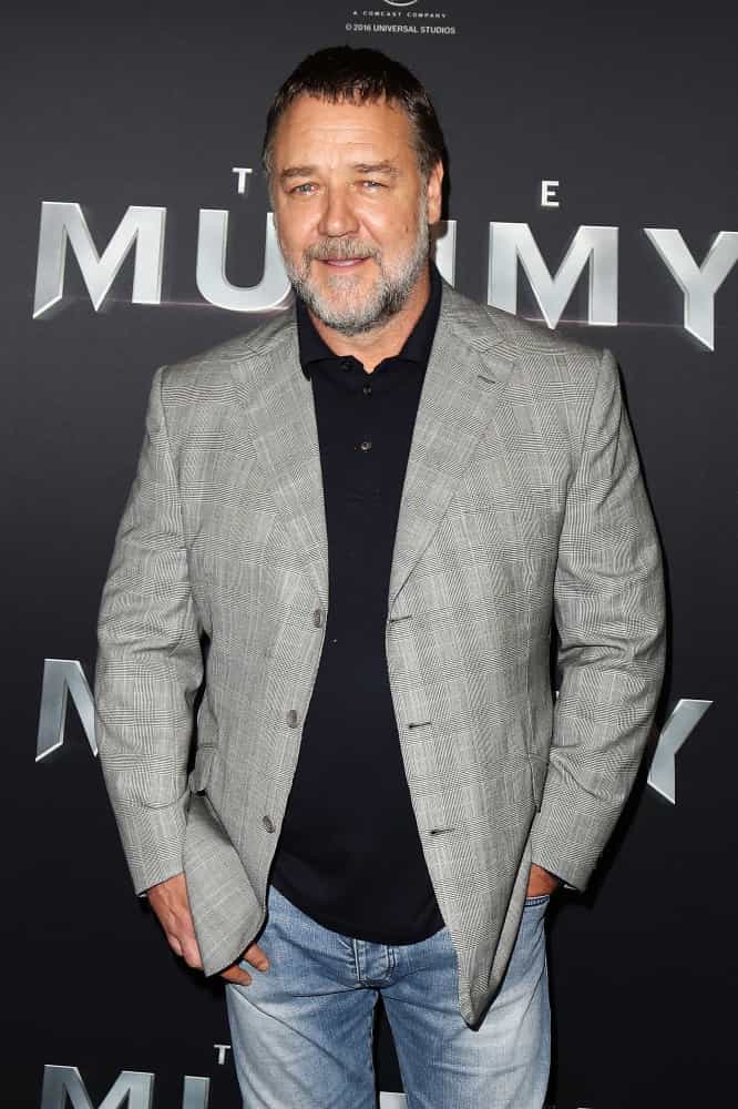Russell Crowe holding a sign posing for the camera