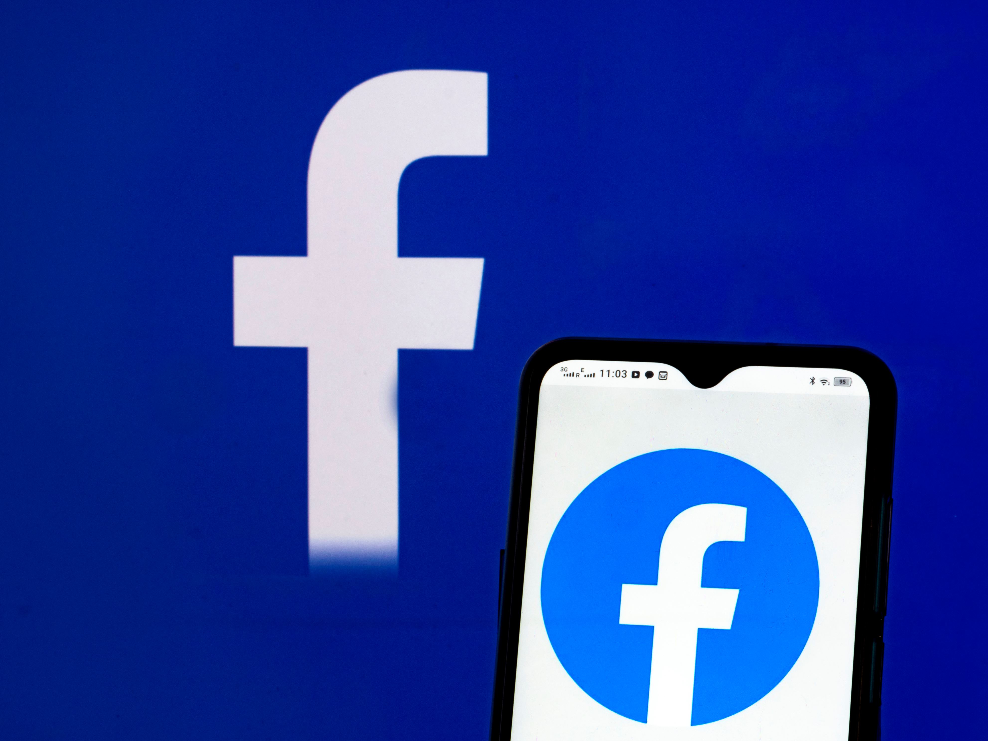 In this photo illustration Facebook, Inc. logo seen displayed on a smartphone and in the background.