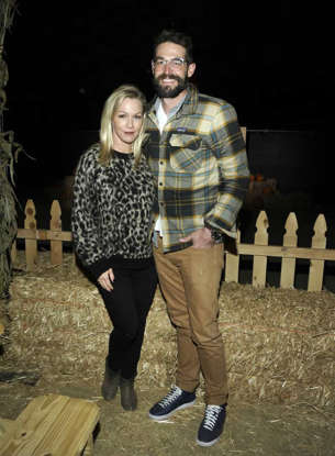 Jennie Garth, Dave Abrams standing in front of a building