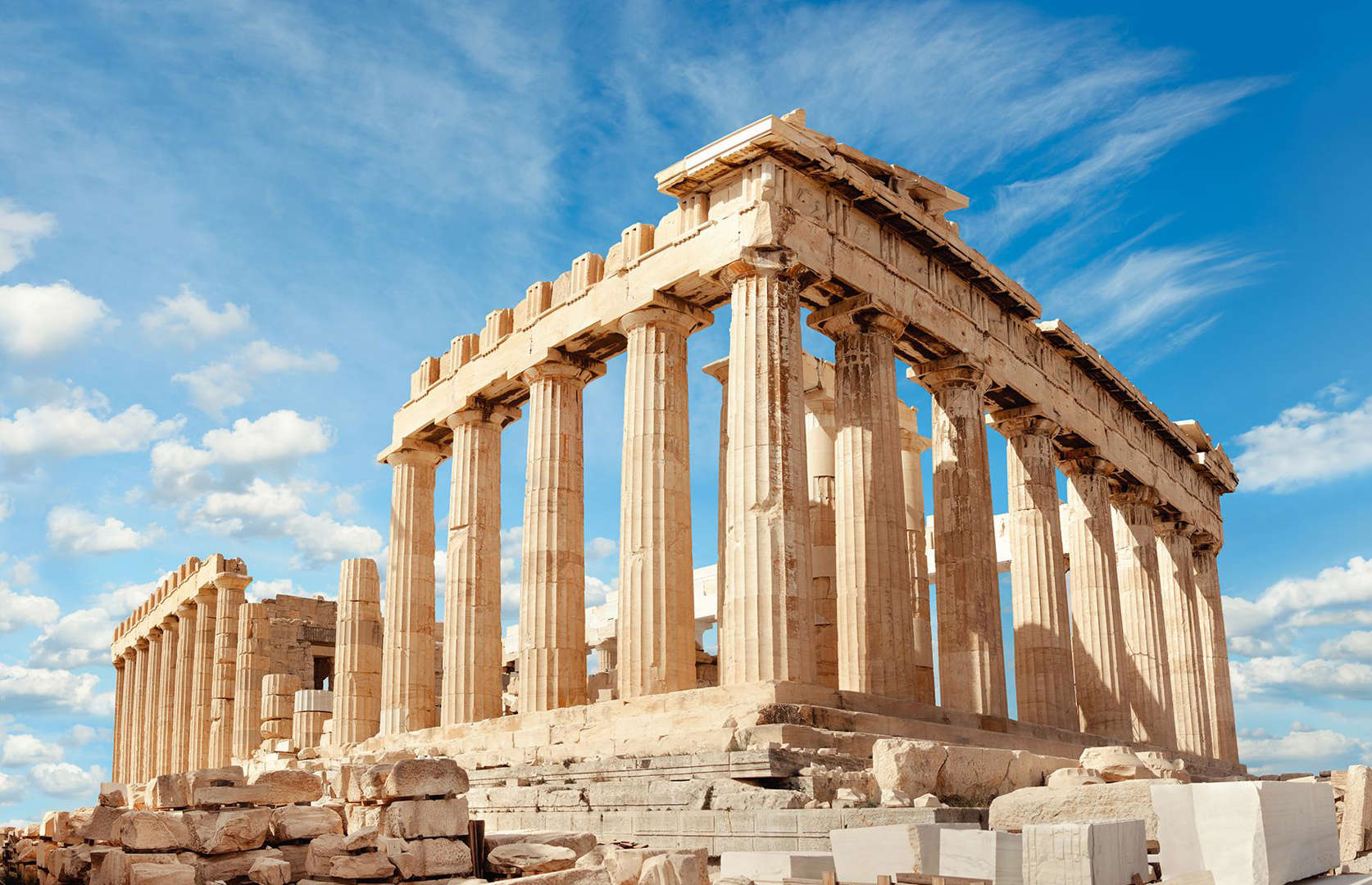 Slide 7 of 41: Taken from a slightly closer angle more than 100 years later, this photograph shows that the Parthenon has changed little over the last century. The columns remain, as does the ruined portico, both rising up amid scattered boulders. Now fragments of the ancient Greek temple are housed (sometimes controversially) in museums around the world, from Paris to Vienna. Among the most impressive are the Elgin Marbles, a series of intricate friezes and sculptures at the British Museum.