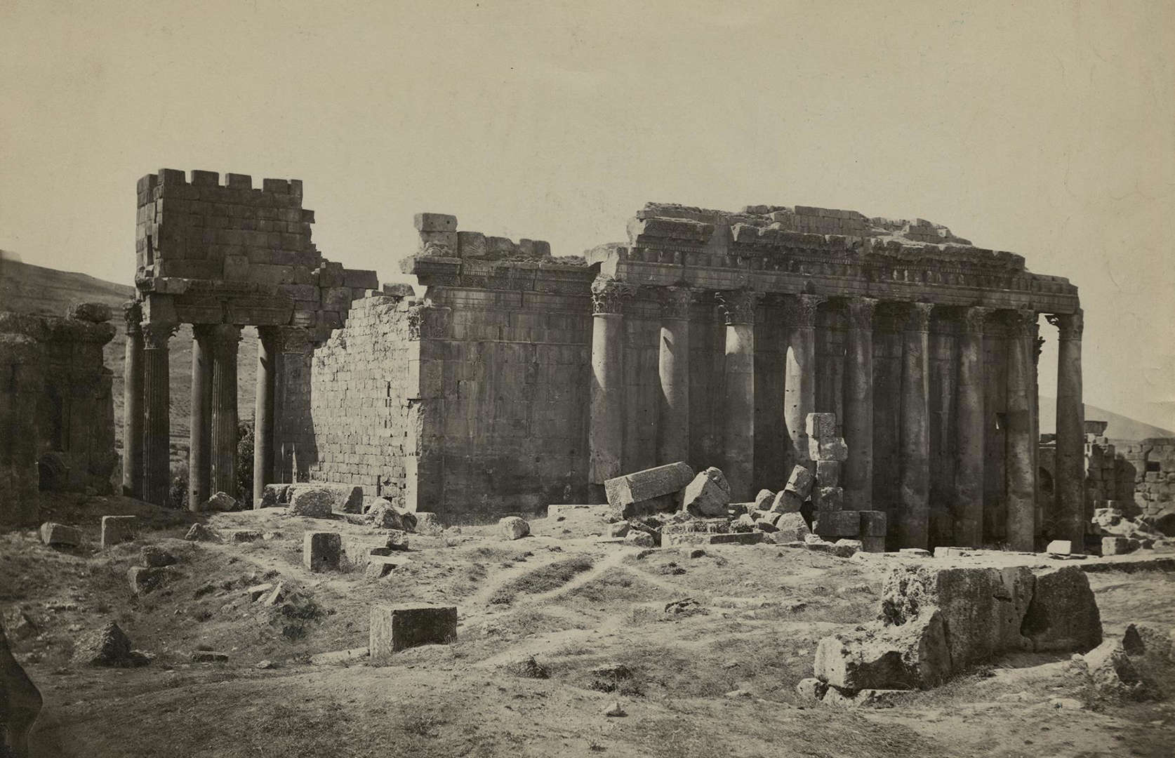 Slide 20 of 41: From one breathtaking remnant of the Roman Empire to another: the Temple of Bacchus is a key site at Baalbek, a ruined Roman town in Lebanon's Beqaa Valley. The temple itself is made up of intricate Corinthian columns and was dedicated to Roman gods of agriculture and fruitfulness. It's pictured here circa 1880, surrounded by rubble, its impressive columns crumbling.