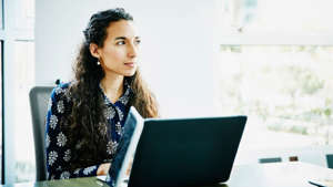 a woman sitting in front of a laptop computer: investment research