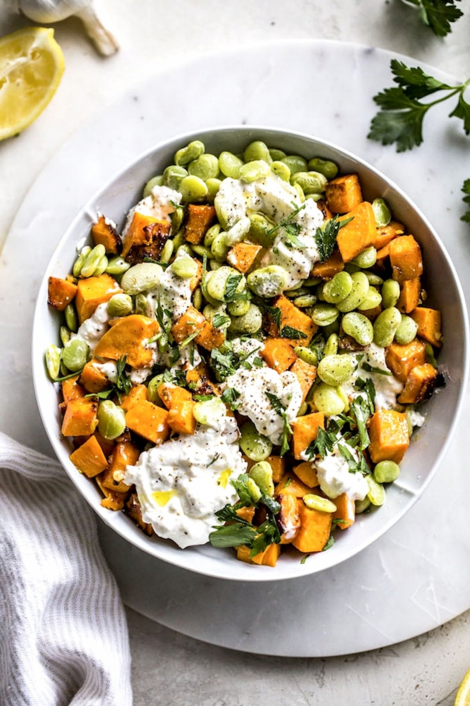 <p>This gorgeous, vibrant salad makes tasty use of frozen lima beans, by combining them in a refreshing salad with sautéed garlicky sweet potatoes and creamy burrata cheese. <a href="https://thealmondeater.com/garlic-lima-bean-salad/" rel="noopener">Get the recipe here.</a></p>