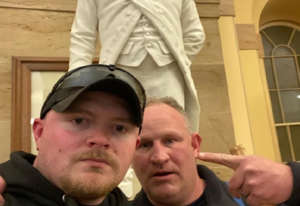 a man and a woman taking a selfie: On Jan. 6, prosecutors said, Thomas Robertson and Jacob Fracker, his then-colleague with the Rocky Mount Police Department, stormed the Capitol and posed for a photo in front of a statue of John Stark.