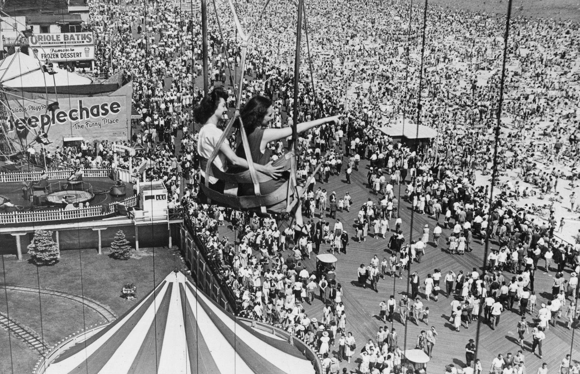 Fast-forward to the 1940s and Coney Island was as popular as ever. In this aerial shot, hordes of vacationers appear like ants across Coney Islands sands and boardwalk, as a pair of women ride the now defunct Parachute Jump. The ride was part of Coney's Steeplechase Park, which closed its gates in the 1960s.