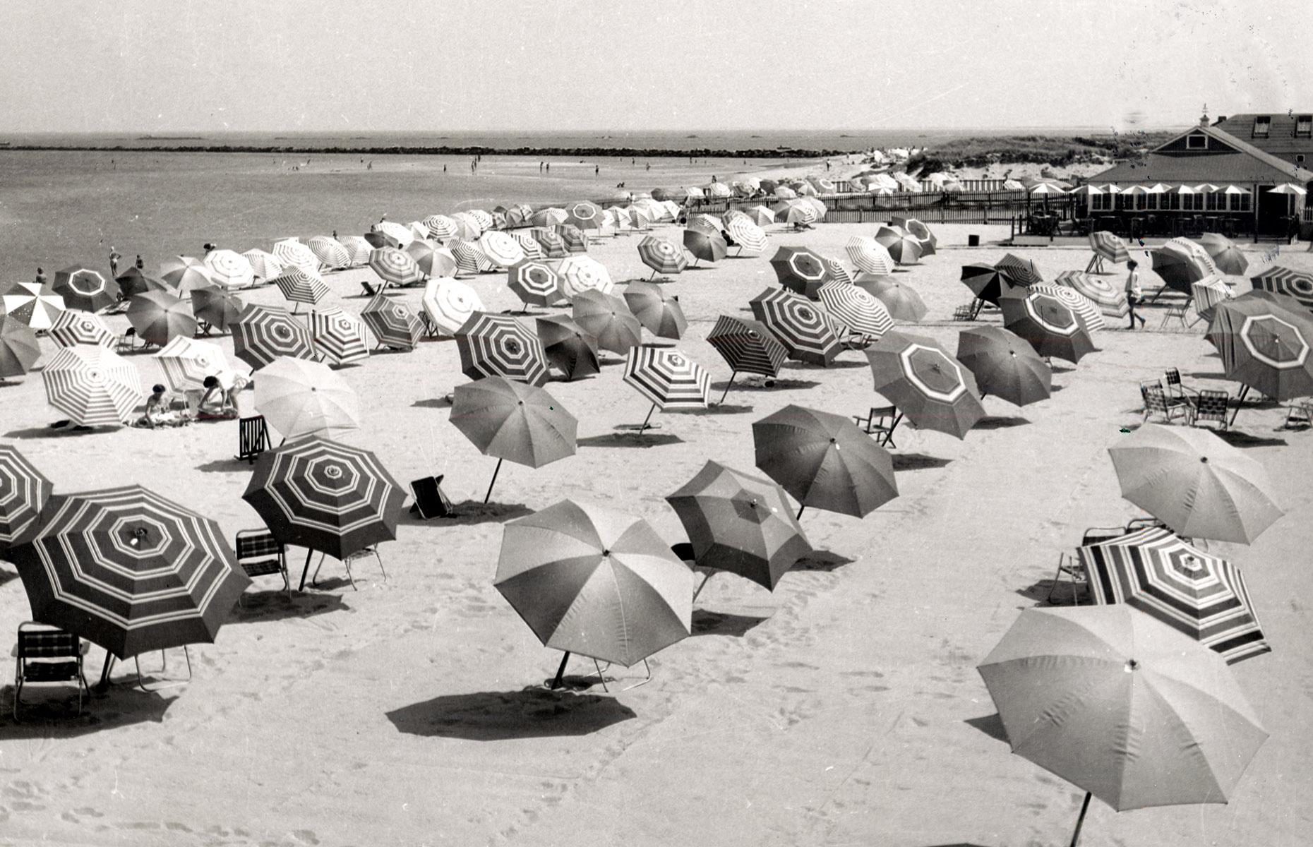 Some three decades later, in the 1950s, Cape Cod's popularity with vacationers showed no sign of waning. This sandy, umbrella-carpeted beach is actually on Nantucket, a dinky island that lies just off the cape.