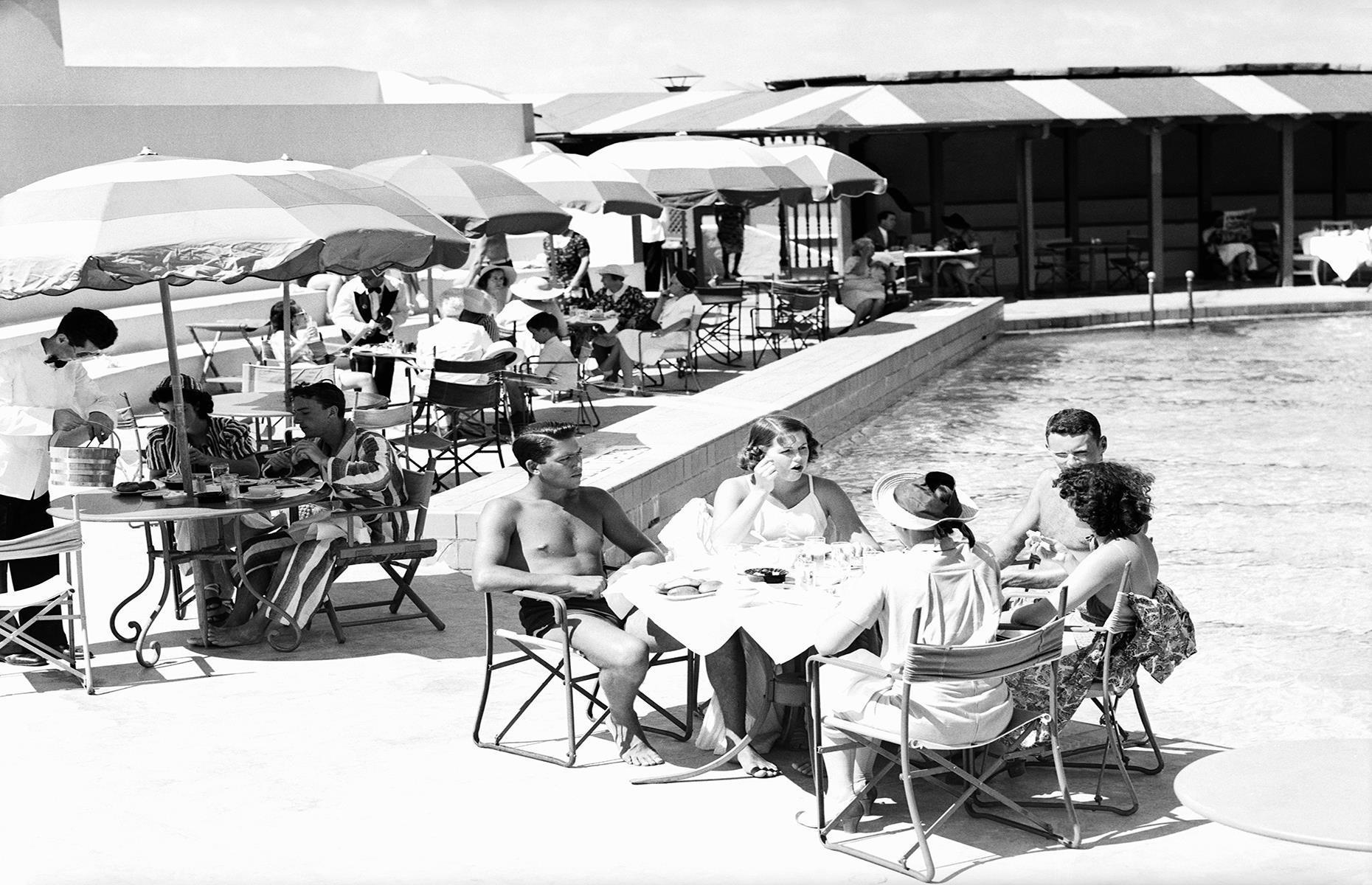 Miami mushroomed in popularity in the first half of the 20th century. Glitzy hotels and resorts sprang up here and vacationers flocked to the city's sand-trimmed shores. This photo dates to the 1930s and captures a group of young holidaymakers having lunch by the pool at a Miami hotel.
