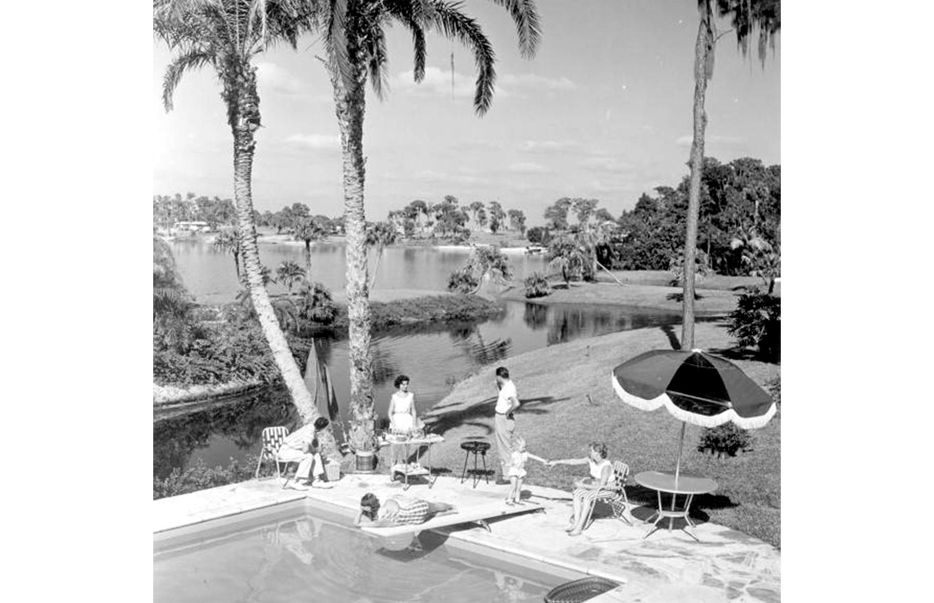 Those who preferred things at a slower pace could relax around Cypress Gardens' patio and pool areas. Papped in 1956, this family enjoys a poolside cook-out under the Florida palms.
