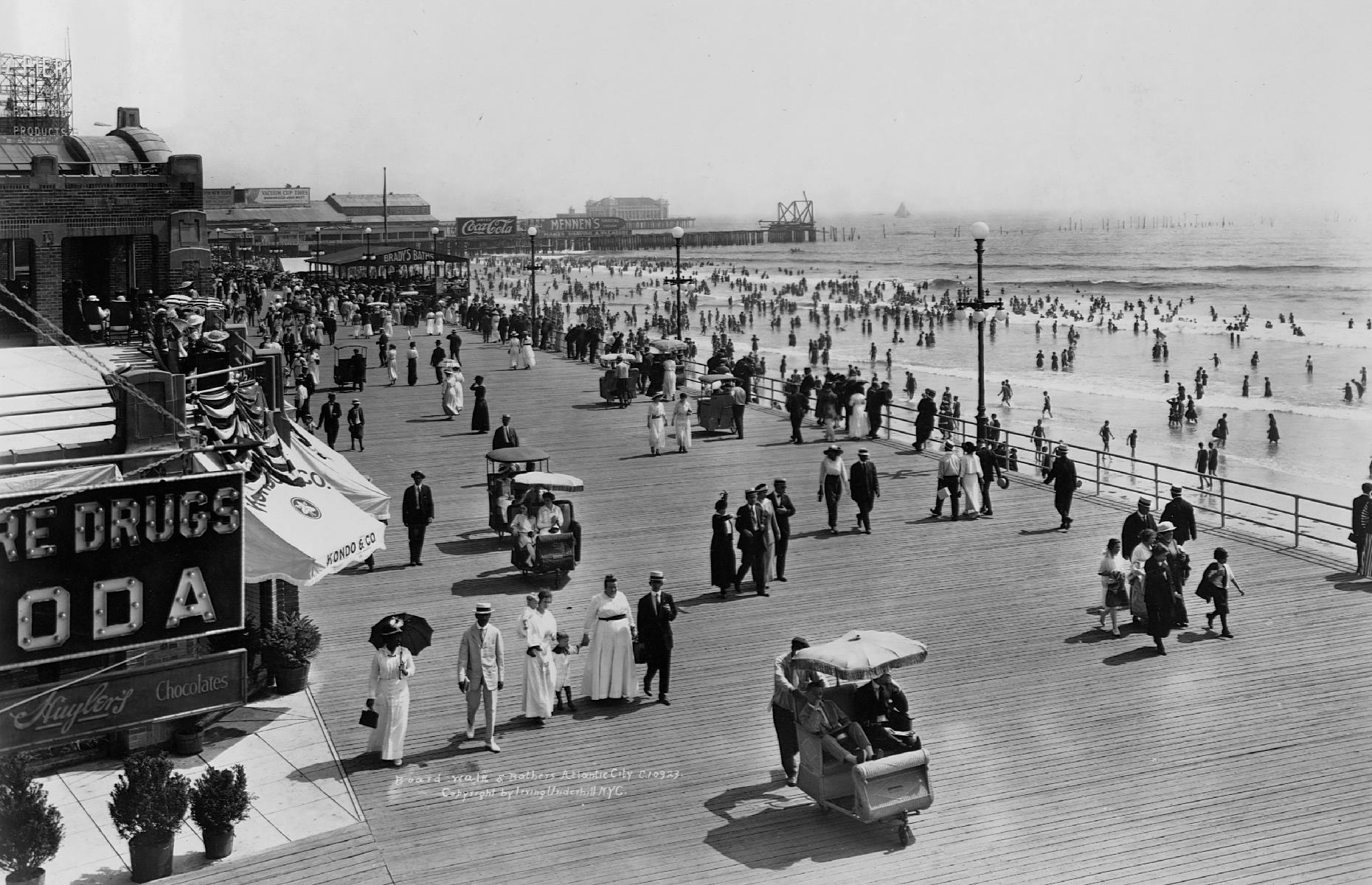 Behind the beach, the Atlantic City Boardwalk, with its hotels, restaurants and casinos, hums with activity too. These vacationers are captured in 1915, several decades after the popular wooden pathway was first completed. The umbrella-topped "rolling chairs" were (and still remain) a popular way to travel around here.