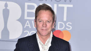 Kiefer Sutherland holding a sign posing for the camera: As reported by Elle, during a 2009 interview Kiefer Sutherland stated that while working with his mother at a Massachusetts theater he “was asked to look after Gwyneth Paltrow.” Kiefer said: "I think it was very funny because it's unbelievable how fast someone goes from 13 to 18, and obviously they look so different that when Gwyneth started to work, I thought, 'Well, that must be another girl because I always remember her as being 11 or 12 years old.'"
