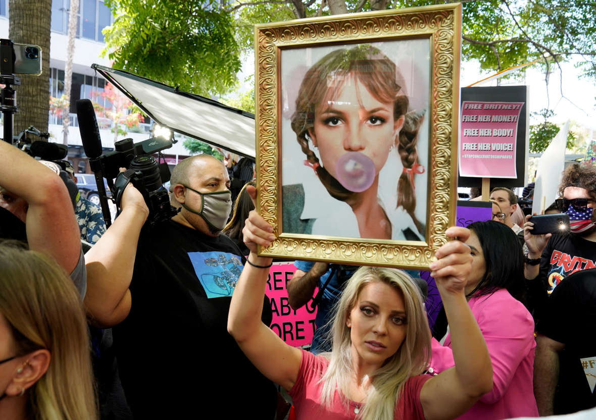 Slide 16 of 27: Britney Spears supporter Stephanie Lewis of Los Angeles holds a portrait of the pop singer outside a hearing concerning the pop singer's conservatorship at the Stanley Mosk Courthouse, Wednesday, July 14, 2021, in Los Angeles.