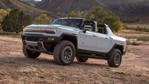 a car parked in the dirt with a mountain in the background: 2022 GMC Hummer EV Driver Side Mountain