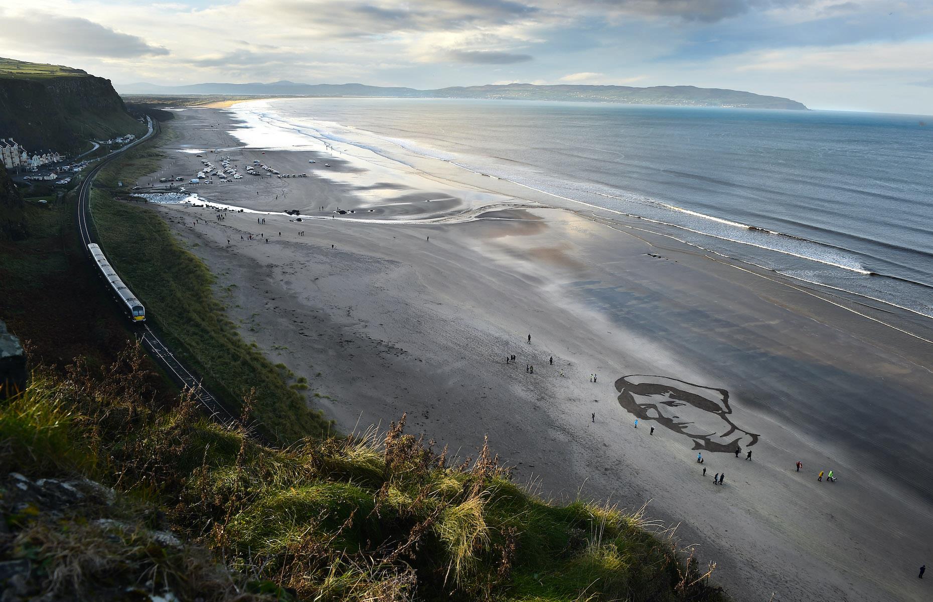 <p>Filmmaker Danny Boyle’s Armistice beach memorial Pages of the Sea was one of the nationwide visual arts projects of remembrance commissioned for the centenary of Armistice Day (the end of the First World War) on 11 November 2018. The striking visual arts project saw large-scale portraits carved into the sand on 32 beaches around the country – pictured here is a portrait drawn on Downhill Beach, County Londonderry, Northern Ireland, of British Army staff nurse Rachel Ferguson who lost her life in Bordighera, Italy, in 1918. The portraits were chosen by Boyle to tell the stories of the ordinary people who gave their lives to the war effort.</p>