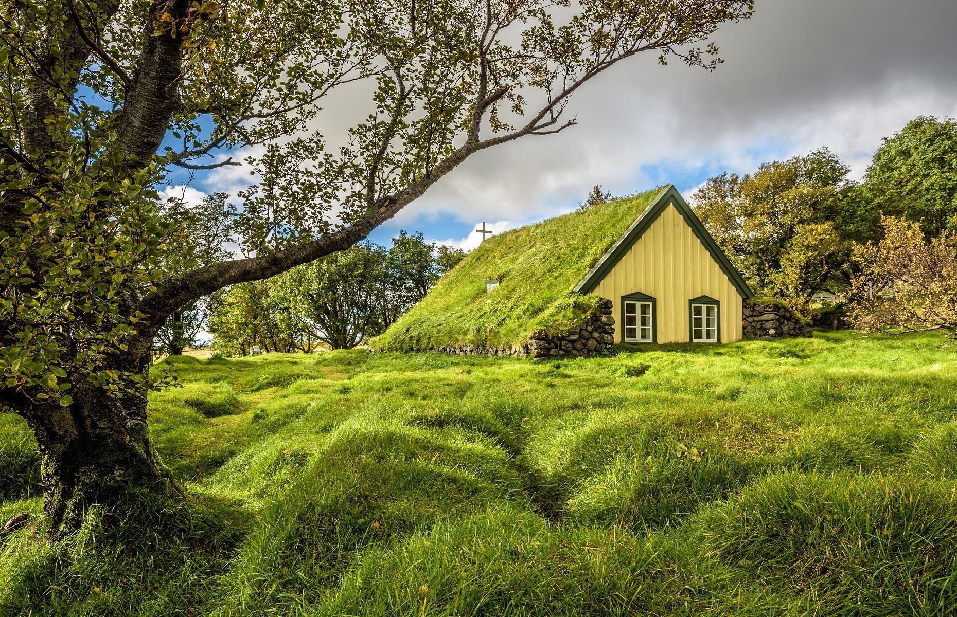 <p>Anyone looking to explore a different side of Iceland should venture to the Skaftafell area of the island. There some truly unique pieces of architecture can be witnessed, including one of the few remaining turf churches. Hofskirkja is embedded in the ground and covered by a vibrant green blanket of grass. Around it sit ancient burial mounds, that are reminiscent of the lava fields found across the country. Dating back to 1884, it was capped by turf to stop the heat escaping in the depths of winter.</p>