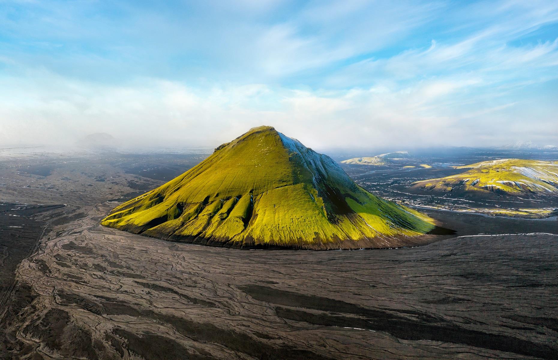 <p>Erupting from a desert of black sand, <a href="https://guidetoiceland.is/travel-iceland/drive/maelifell">Mælifell</a> is arguably Iceland's most astonishing volcano. Standing proud at almost 2,600 feet (791m), this majestic mountain was once concealed beneath Mýrdalsjökull glacier. When the ice retreated some 10,000 years ago, Mælifell became the focal feature of the landscape. Only accessible between June and September, the volcano is a popular spot for hikers, braving the unique and at times inhospitable terrain of southern Iceland.</p>