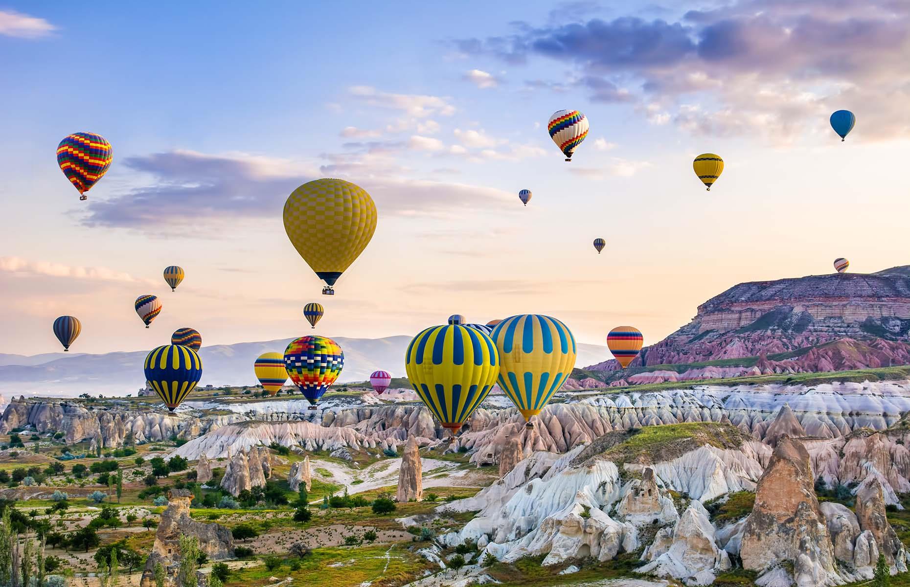 A group of brightly-coloured hot air balloons are seen here gliding over the historic landscape of Cappadocia in central Turkey. The unique rock formations in this region have been shaped by erosion and volcanic activity, and are known as fairy chimneys. Thanks to the unusual landscape below, Cappadocia is a popular destination for hot air balloon enthusiasts as well as those who wish to marvel at the rocks from above.