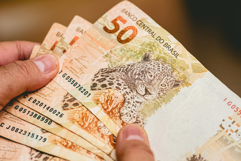 Real currency. Money from Brazil. Woman holding in hands a fifty Reais banknotes.