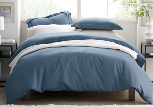a bedroom with a large bed sitting in a room: Wrinkle-free sateen duvet cover