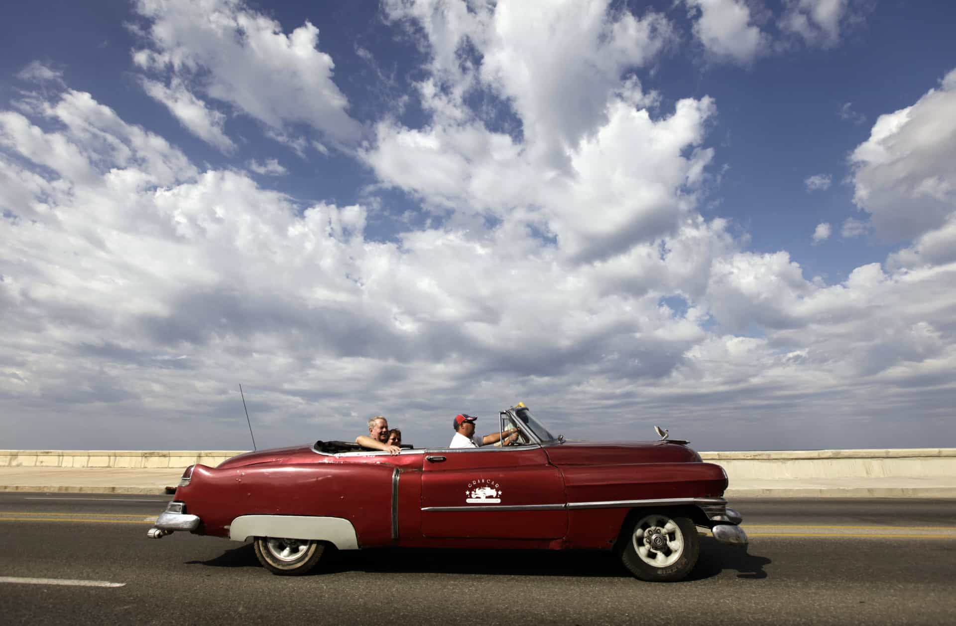 Tourists drive around in a 1952 convertible Cadillac.