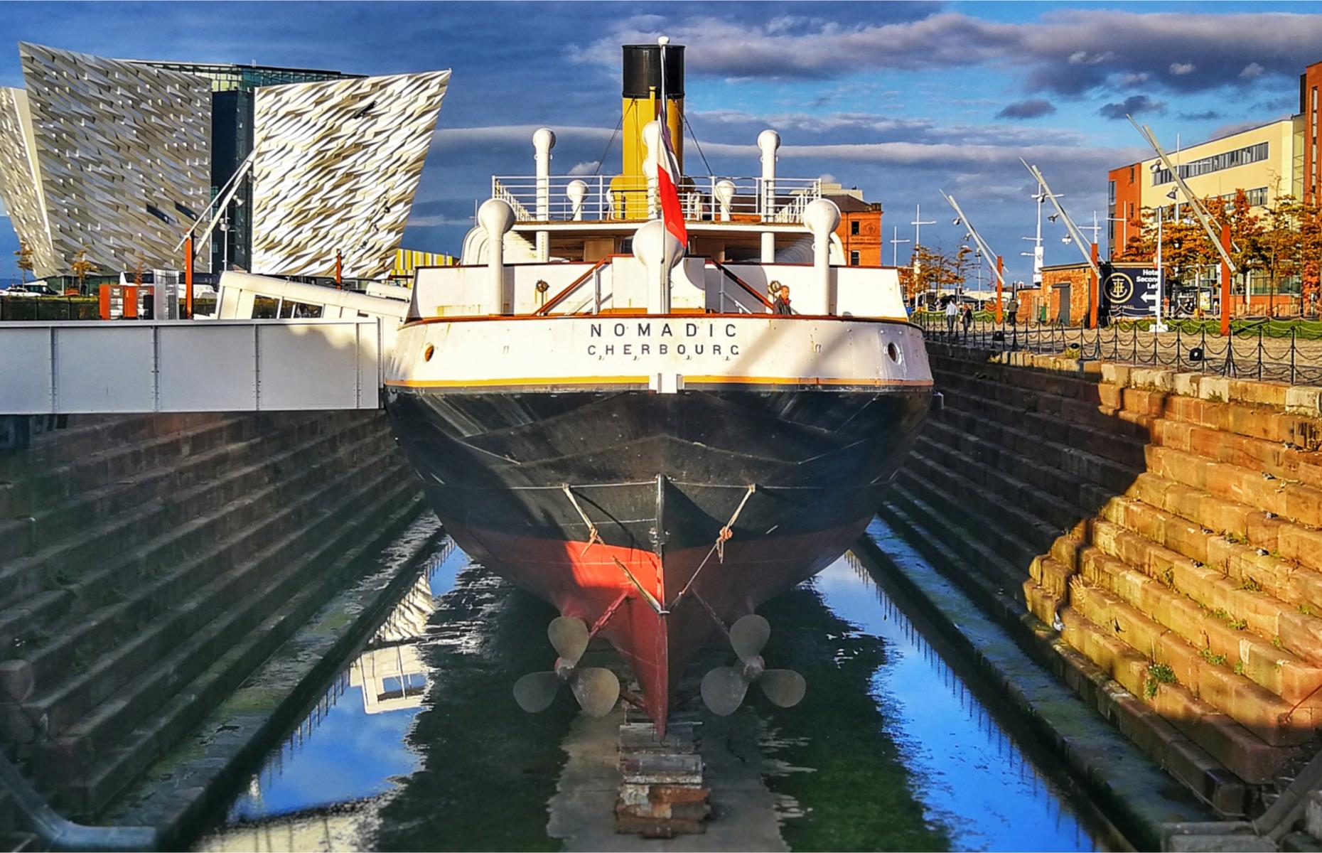 <p>The SS Nomadic, built in 1911 and designed by Titanic architect Thomas Andrews, is the only White Star Line ship still in existence. Her function was as a tender, to transport passengers onto the Titanic and her sister ship RMS Olympic at Cherbourg, France, where the harbour was too small for the liners to dock. The Nomadic would have transported the Astors and fellow American businessman Benjamin Guggenheim, among other first and second class passengers, out to the Titanic. Saved from the scrapheap, <a href="https://www.titanicbelfast.com/explore/ss-nomadic/">the Nomadic is now back in Belfast's historic Hamilton Dock</a> and can be boarded as part of the Titanic Experience.</p>