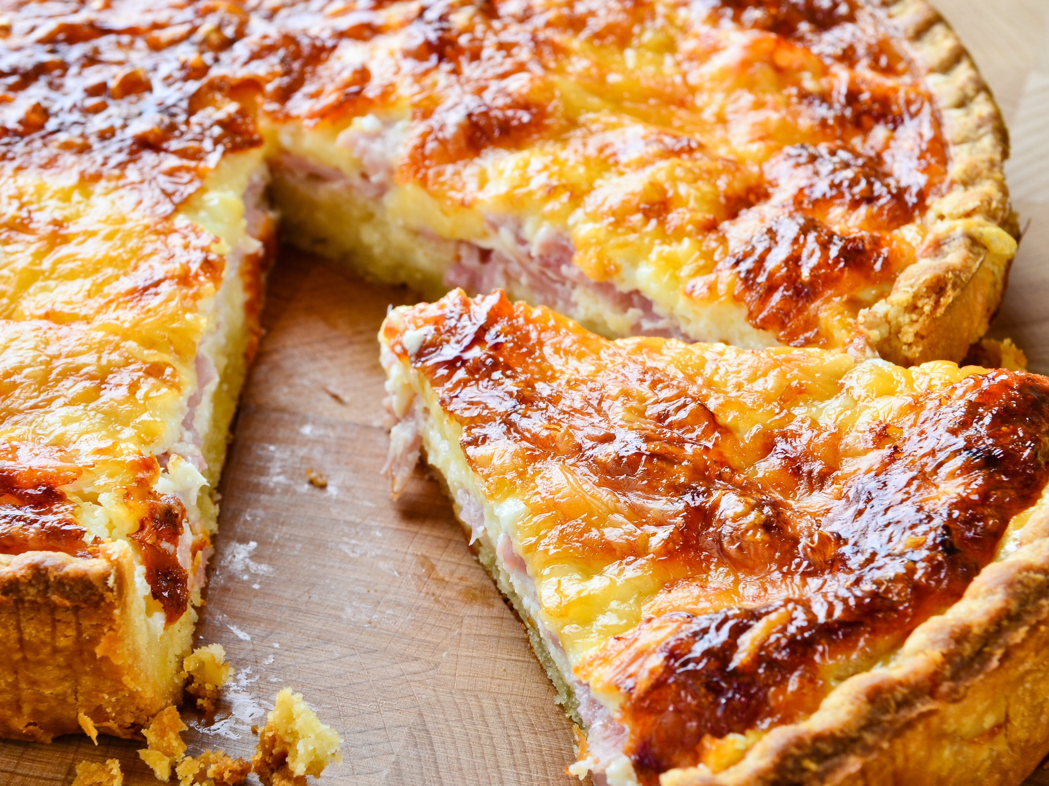 <p>This flaky dish has a rich history. </p><p><a href="https://cooking.nytimes.com/guides/29-how-to-make-quiche">According to the New York Times</a>, quiche Lorraine is named after the historical region in northeastern France that was heavily influenced by Germany, though open-faced tarts were around since medieval times. </p><p>It's usually <a href="https://cooking.nytimes.com/recipes/1019773-quiche-lorraine?searchResultPosition=1">made</a> with <a href="https://www.insider.com/the-best-celebrity-chef-recipe-for-well-done-steak-2021-9">mashed butter</a> mixed with eggs worked into a flat disc of dough. After it's baked, it's covered in grated Gruyère, nutmeg-filled custard, and cooked pancetta. </p>