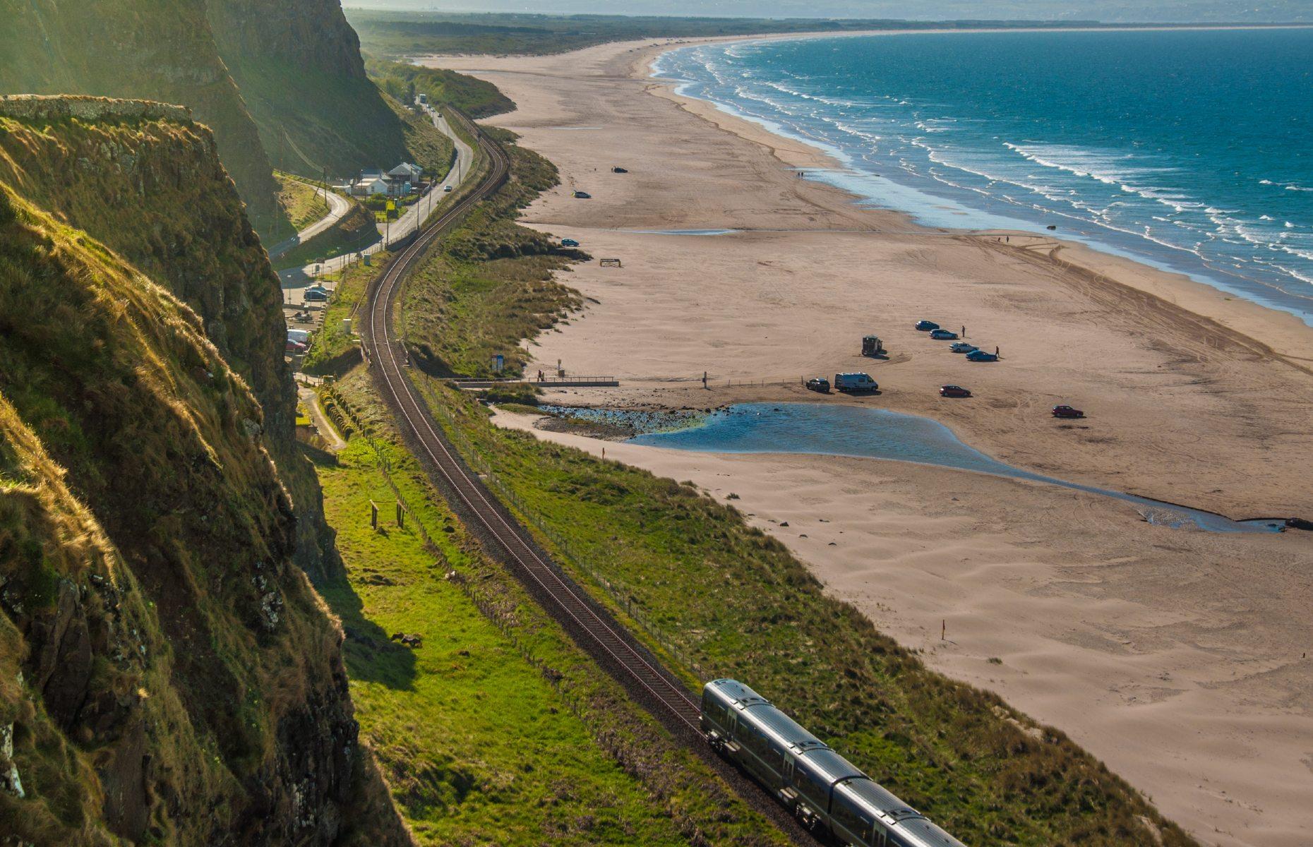 <p>Winding through some of Northern Ireland’s most picturesque spots, we can see why actor and explorer Michael Palin described this short train ride as <a href="https://www.belfasttelegraph.co.uk/news/northern-ireland/michael-palins-favourite-railway-line-between-coleraine-and-derry-in-northern-ireland-set-to-re-open-following-upgrade-35227689.html">“one of the most beautiful rail journeys in the world”</a>. Although just under an hour-long, the <a href="https://www.translink.co.uk/">29-mile (47km) railway</a> between Derry and Coleraine packs in plenty of stunning sights. Following the River Foyle, the route showcases breathtaking views of the golden sands of Benone Strand, colourful seaside villages and the magnificent Binevenagh Mountain.</p>