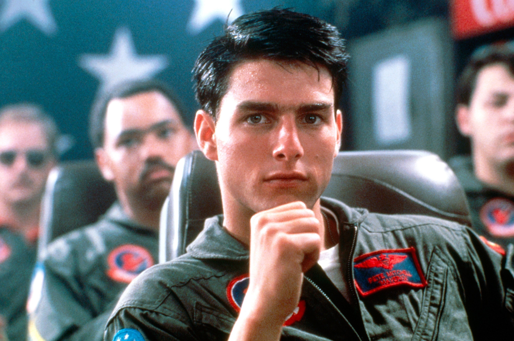 <p>Tom Cruise is seen here in 1986’s ‘Top Gun’. He played US Navy pilot LT Pete ‘Maverick’ Mitchell, who attends The Top Gun Naval Fighter Weapons School and brings his cocky attitude along with him.</p> <p>‘Top Gun’ producer Jerry Bruckheimer revealed that “it wasn’t easy” to convince Cruise to take the role in a May 2021 interview with <em>Variety.</em> They ended up wooing the actor with his own ride on a Navy jet. </p> <p>He recalled, “They took him up on an F-14 and flipped him and did all kinds of stunts to turn him around and make sure he never got back in a cockpit. But it was just the opposite. He landed and he walked over to a phone booth and called me up and said, ‘Jerry. I’m making the movie. I love it.’ He became an amazing aviator himself. He can fly just about any plane they can make.”</p>