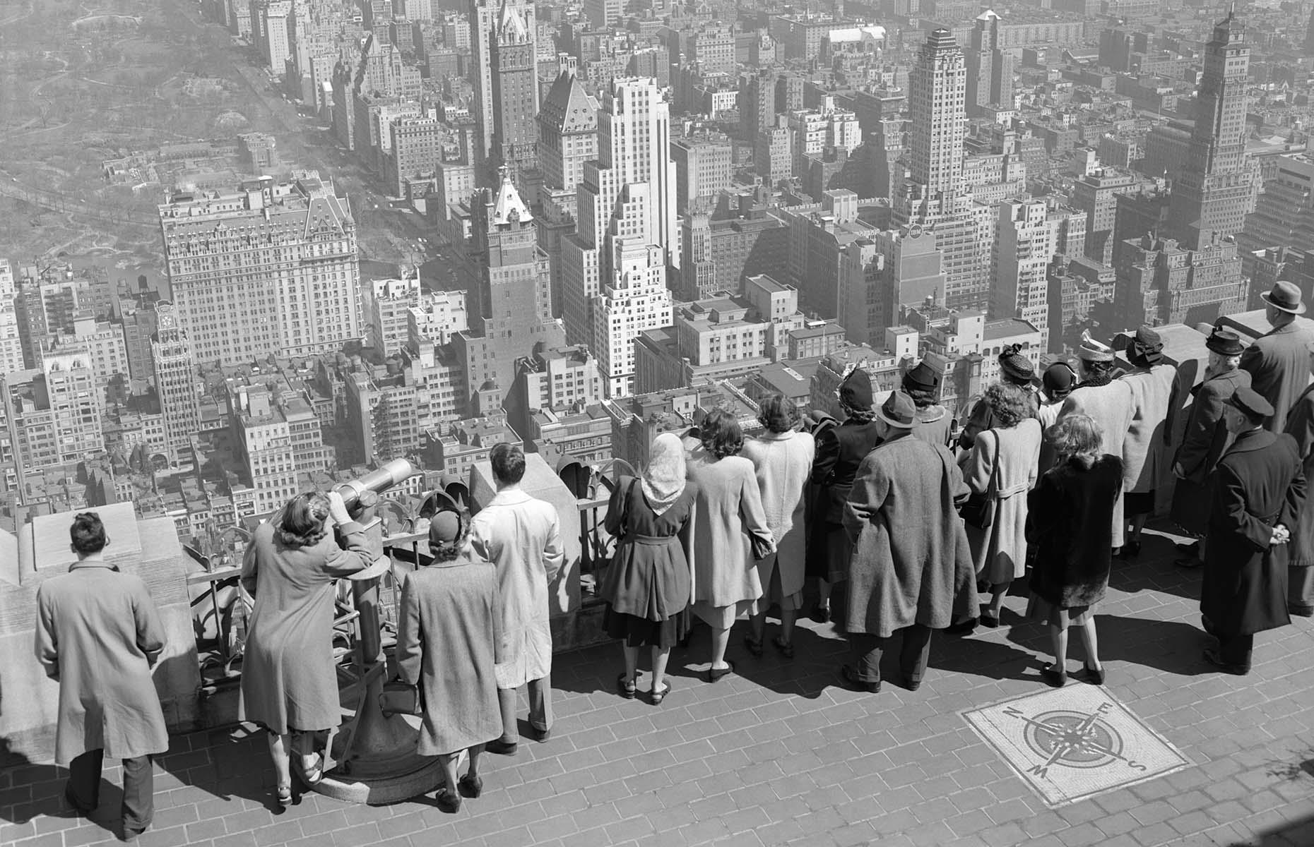 Famous for its abundance of skyscrapers, which were still a rarity in Europe, New York City continued to attract millions of visitors in the post-war era. Just like the travelers of today, these visitors from the 1940s line the edge of the observation deck at 30 Rockefeller Plaza (formerly the RCA Building), looking north towards Central Park, with the breathtaking Manhattan skyline surrounding it.