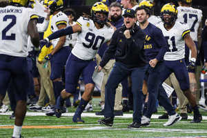 Michigan coach Jim Harbaugh celebrates a play against Iowa during the first half of the Big Ten championship game at Lucas Oil Stadium in Indianapolis on Saturday, Dec. 4, 2021.