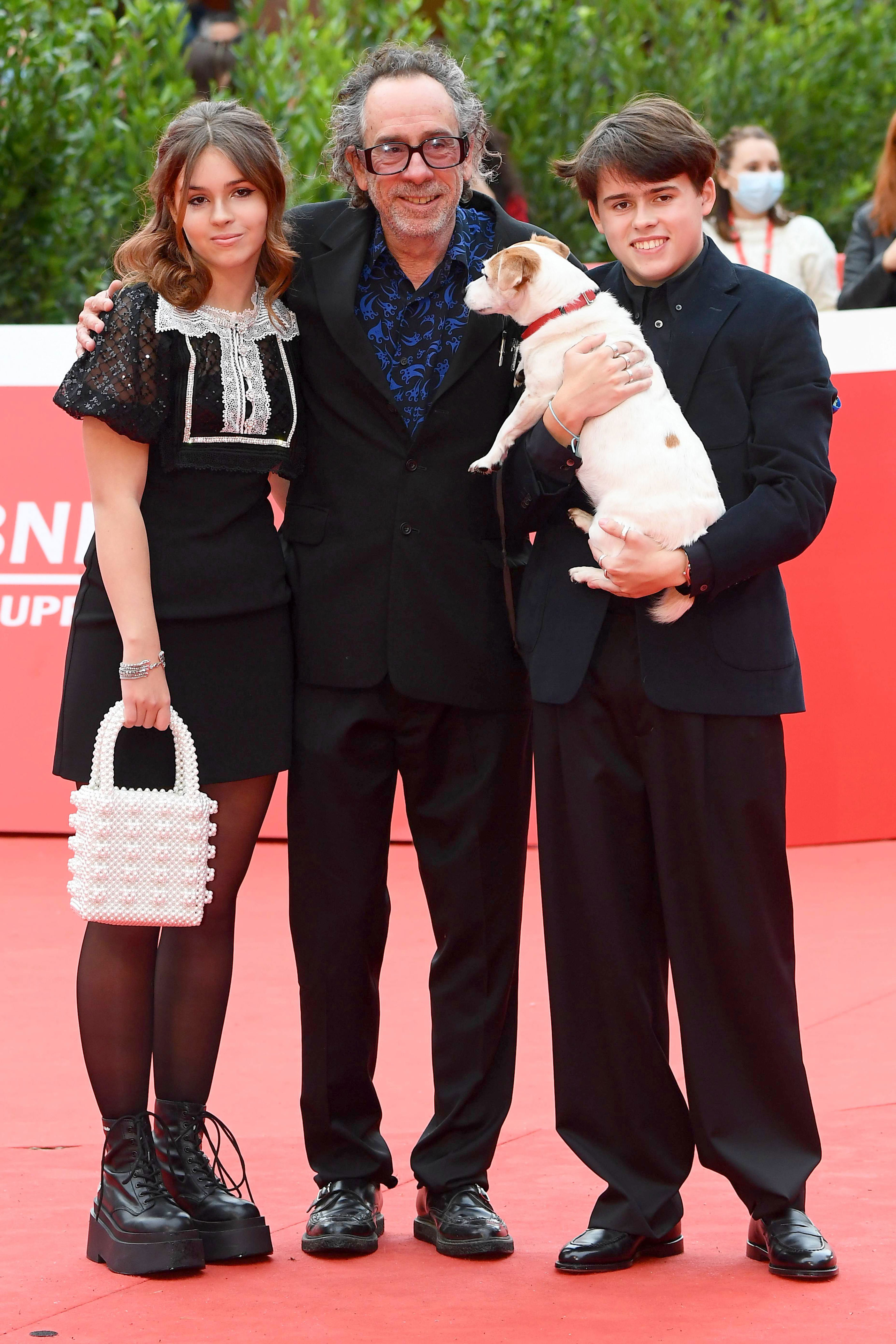 <p>Tim Burton and kids Nell Burton (who was born in 2007) and Billy Burton (who was born in 2003) and their dog, Levi, hit the red carpet to celebrate the filmmaker's Tim Burton Lifetime Achievement Award during the Rome Film Festival in Italy on Oct. 23, 2021.</p>