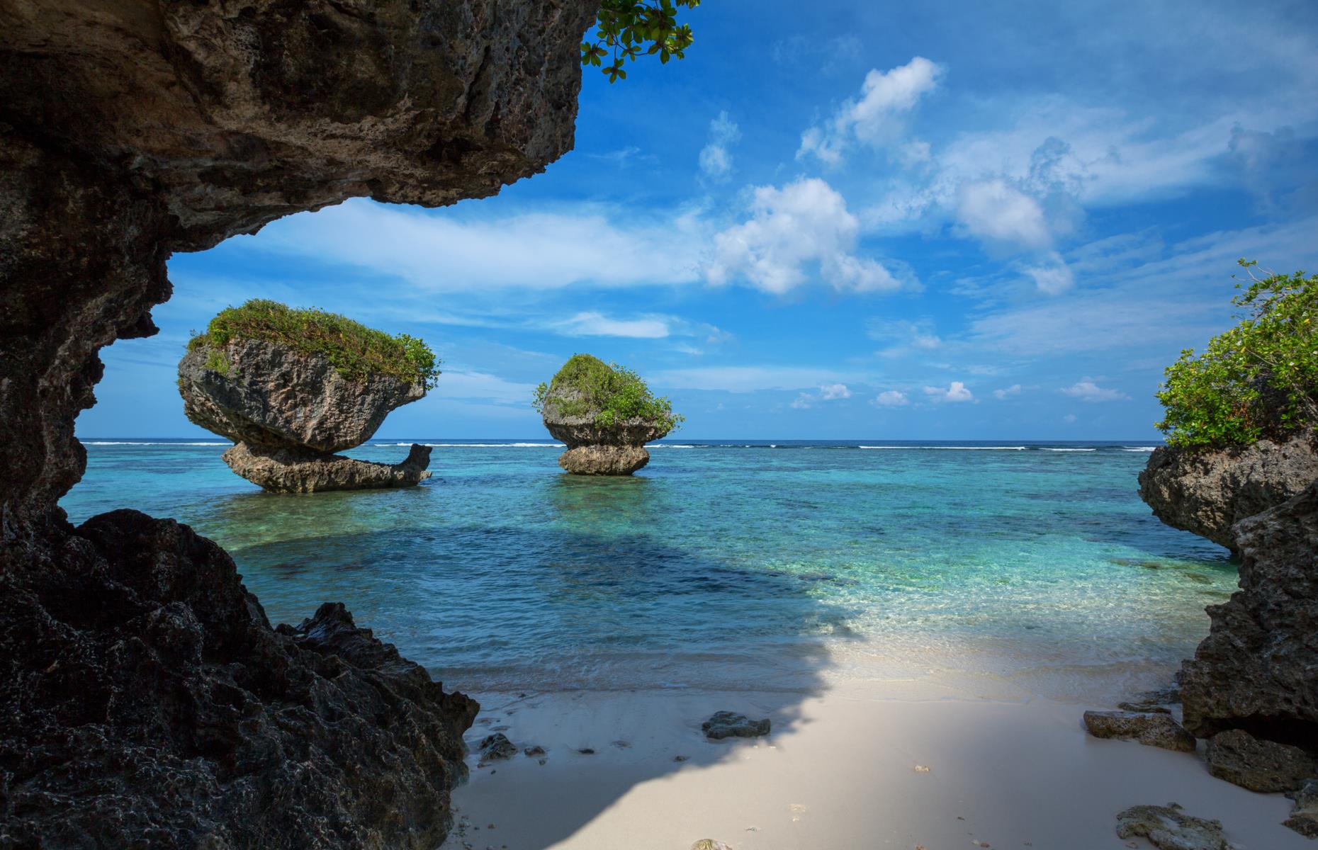 <p>The tropical island of Guam, a US territory in the western Pacific, has incredibly consistent temperatures with <a href="https://www.climatestotravel.com/climate/guam">average highs</a> hovering around 86-88°F (30-31°C) all year. While it can be rainy as it lies in the path of typhoons, the best time to visit is usually February-April when it’s relatively dry and calm. The scenery and atmosphere add to the glow, from the flavorsome and often fiery Chamorro cuisine to the rock formations and shortbread-hued sands of Tanguisson Beach (pictured).</p>