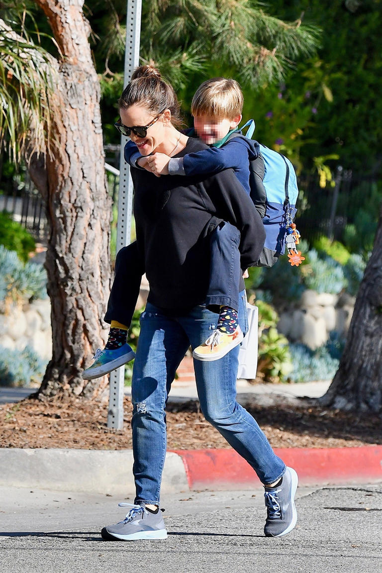 Jennifer Garner giggles as she gives son, Samuel, a piggyback ride after picking him up from school on Feb. 23, 2020. The two were all smiles as they made their way down the sidewalk.