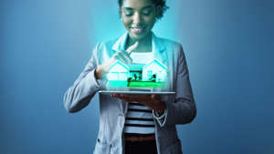 young businesswoman views online digital real estate on tablet metaverse concept_iStock-1041512634