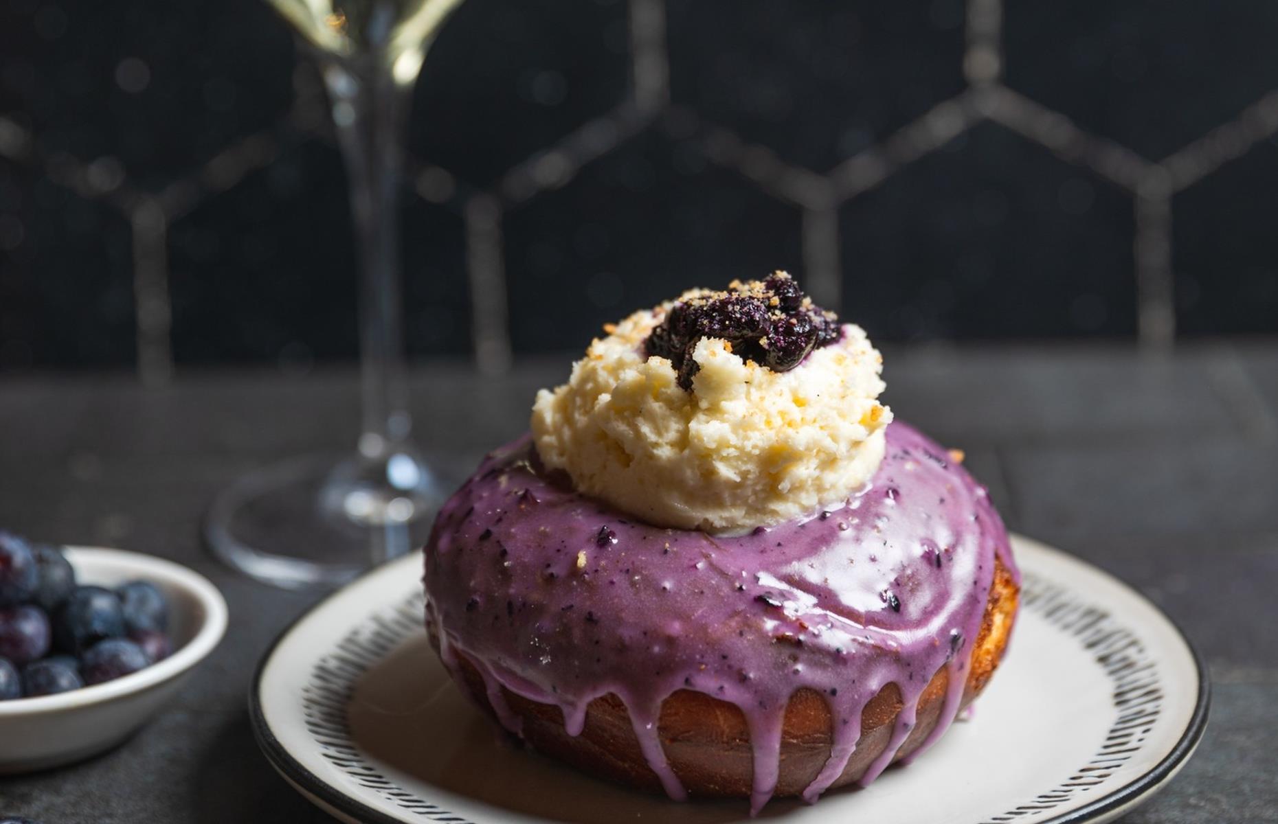 <p>At least two indulgent treats packed into one delicious round, this Blueberries & Champagne donut from California mini-chain <a href="https://www.facebook.com/SidecarDoughnuts/">Sidecar</a> is the ultimate in sweet luxury. One of the company’s regular seasonal specials, released for early 2022, it starts with a raised bullseye donut (a traditional style with a little divot to hold a dollop of something) and is dipped in blueberry glaze and topped with blueberry and Champagne compote, lemon cheesecake mousse and crumbled sugar cookies.</p>