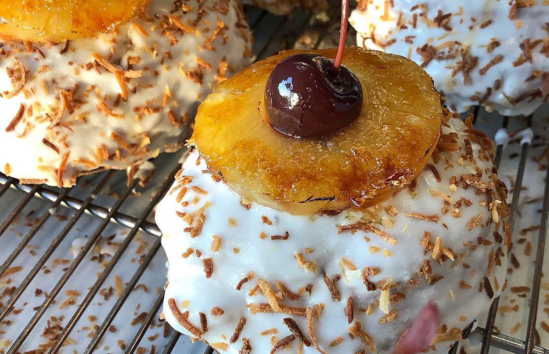 <p>If you like piña coladas (and whether or not you like getting caught in the rain), you would love this special creation from <a href="https://www.districtdonuts.com/">District</a> in New Orleans. The limited-edition donut was inspired by the classic holiday cocktail with a generous smothering of frosting, plenty of desiccated coconut and a topping of caramelized pineapple and a maraschino cherry.</p>